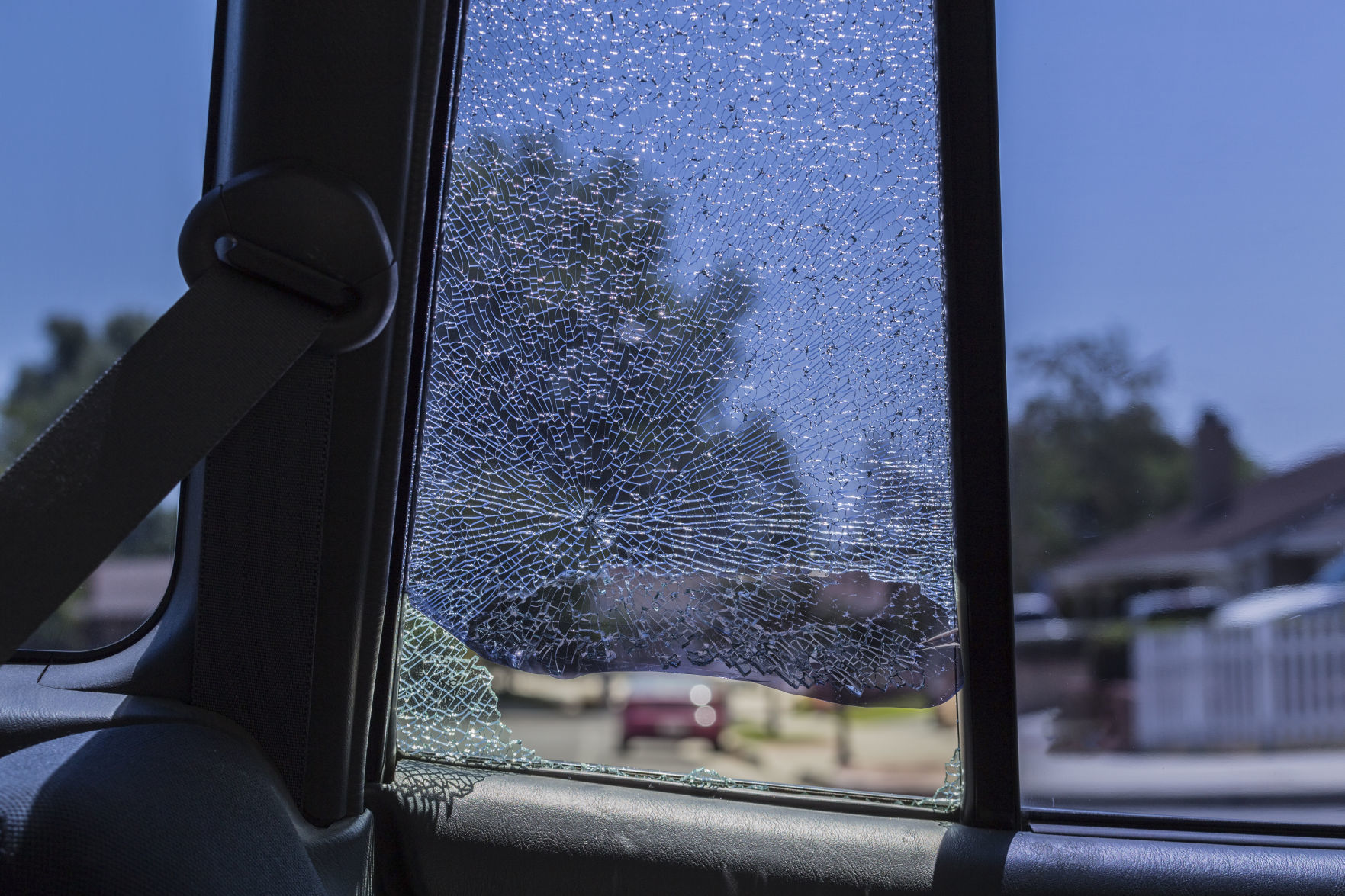 Smashed rear car door window from vehicle burglary. Inside looking out.
